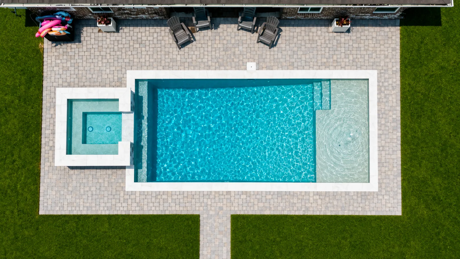Custom pool with a tanning ledge and paver decking