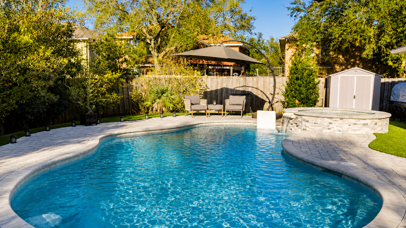 Freeform custom pool with raised spa and spillover waterfall by Neway Pools Freeform custom pool with raised spa and spillover waterfall by Neway Pools